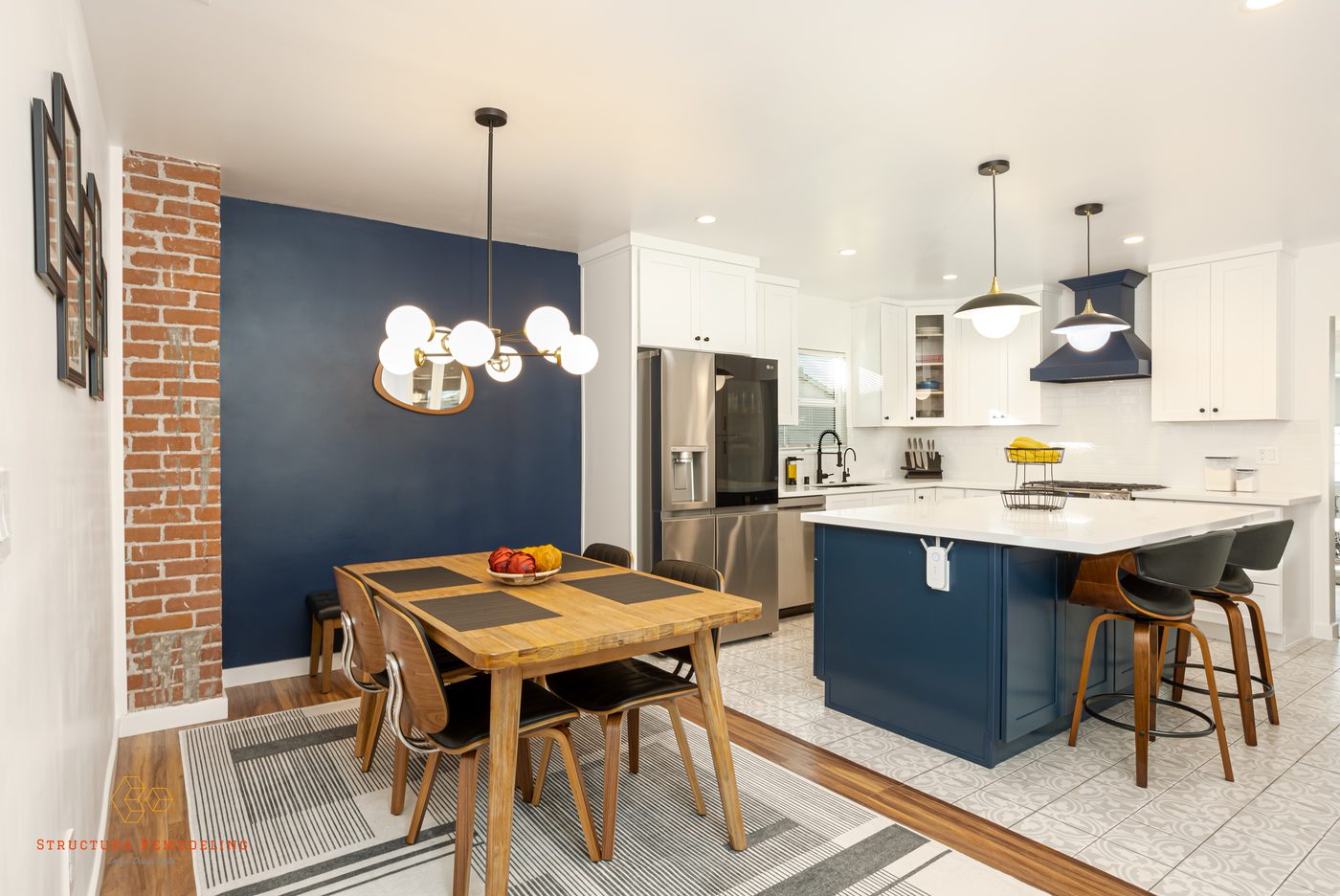 Open space concept kitchen with navy blue island, brick accent wall, and dining area in Gardena