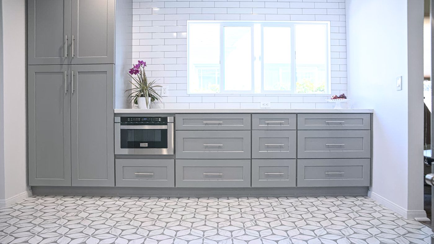 Gray shaker kitchen with patterned tile floor, subway tile backsplash, and marble counters in Santa Monica