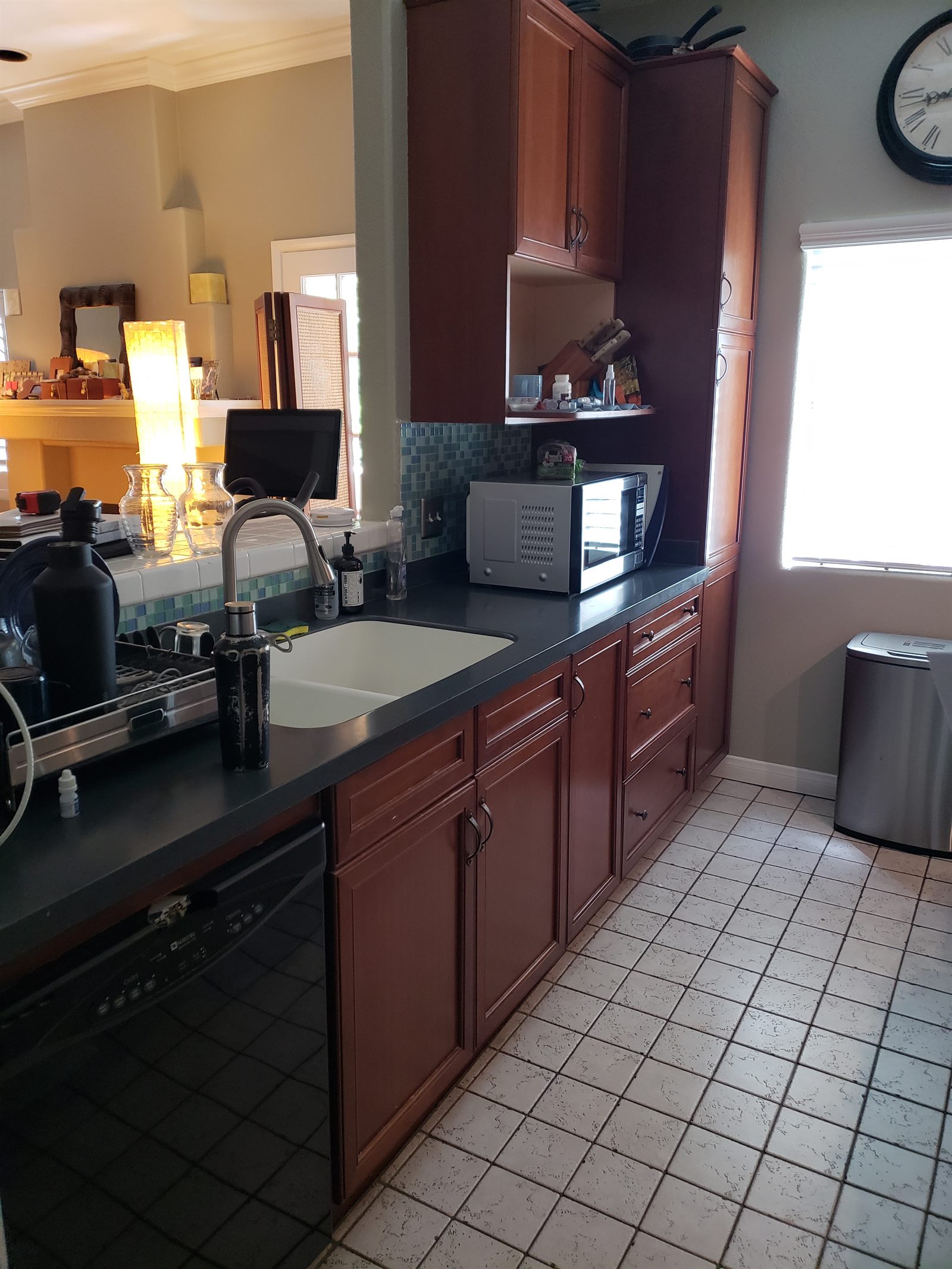 Before: original Studio City kitchen sink area with dated cabinets and flooring